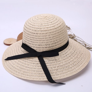 Women's summer straw sun hat with wide brim and black ribbon bow on white background
