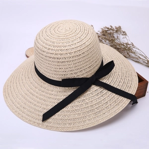 Detailed macro view of the woven straw texture and elegant black ribbon bow on summer hat
