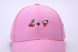 Close-up of cute 3D fruit embroidery on pink cotton baseball cap with fine stitching