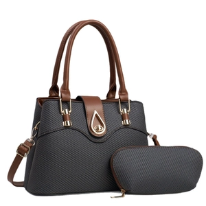 Two-piece dark grey woven crossbody bag set with brown leather handles and gold lock