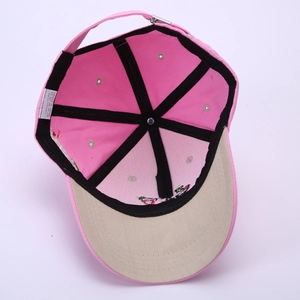 Detail of pink cotton baseball cap interior with black reinforcing tape and metal buckle