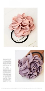 Detailed view of pink and lilac silk flower hair scrunchies with elastic bands