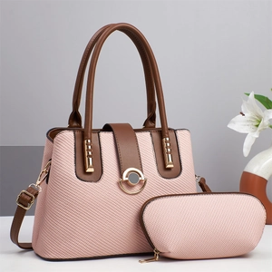 Dettaglio della borsa a tracolla intrecciata rosa con finiture dorate e pochette abbinata
