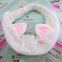 Dettaglio fascia per capelli con orecchie di gatto in peluche bianco e rosa