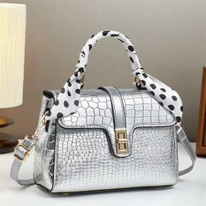 Sac à main carré argenté avec motif crocodile et foulard en soie à pois sur la poignée