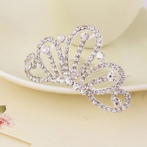 Detail view of a silver crown hair comb with sparkling rhinestones on a decorative plate