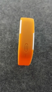 Vue latérale détaillée de la montre de sport LED orange avec rayures blanches et bouton