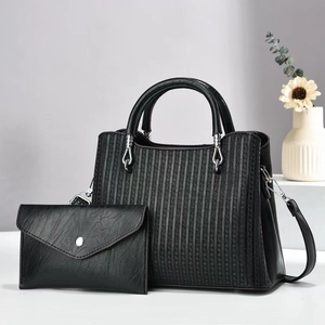 Detail of black faux leather handbag set with geometric texture and silver hardware