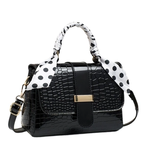 Elegant black crocodile pattern handbag with polka dot scarf handle and gold buckle