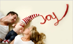 Detail view of long-tail knitted baby hat forming joy shape on warm background