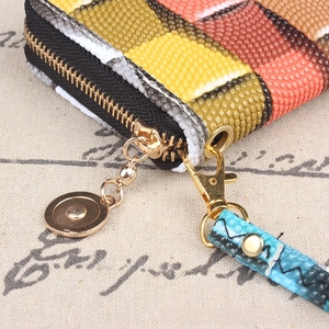 Close-up of vibrant woven ethnic wallet showing golden zipper and textured details
