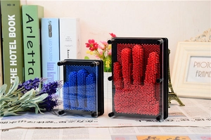 Detailed view of red and blue 3D Pin Art toy showing hand impressions on plastic pins