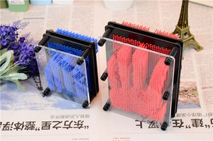 Detail of red and blue 3D pin art clone toys showcasing plastic needles and black frames