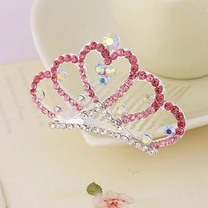 Detailed macro view of pink rhinestones and iridescent crystals on a silver crown hair comb