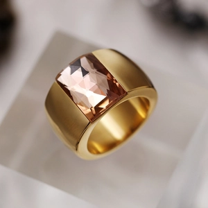 Macro shot of gold titanium ring featuring a large square-cut brown gemstone inlay
