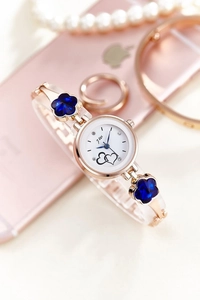 Detailed macro view of a rose gold quartz watch with blue floral gemstone accents
