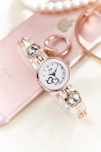 Detail of rose gold bracelet watch with crystal flower links and heart dial design