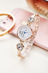 Detailed macro view of rose gold watch band with floral crystals and white dial