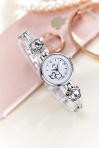 Detail of silver quartz watch with floral crystal band and heart pattern dial