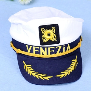 Detailed view of white sailor hat with Venezia embroidery and golden anchor badge