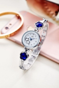 Elegant silver quartz watch with blue floral jewelry band on a stylish table display