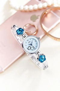 Detail of silver ladies quartz watch featuring blue crystal flowers and heart dial
