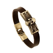 Detail of vintage brown leather bracelet with bronze skull charm and geometric texture