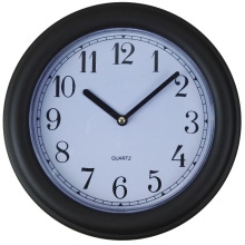 Detail showing the black frame and large Arabic numerals on the white clock face