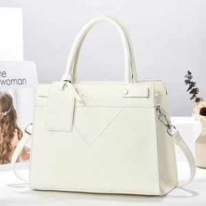 Close-up of beige lychee texture crossbody tote bag with V-shaped stitching and silver rivets