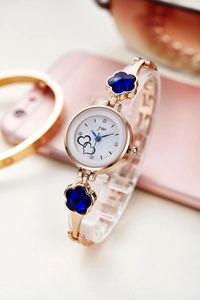 Detail of rose gold watch strap with blue flower crystals and white dial with hearts