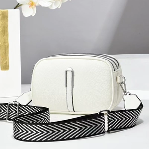 Detail of white litchi pattern camera bag with three-layer zipper and herringbone strap