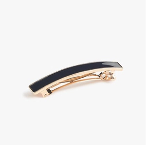 Detail view of a long rectangular hair clip with smooth black enamel finish and metal base