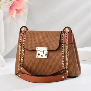 Minimalistische geweven bruine crossbodytas met gouden gesp op een geometrisch voetstuk