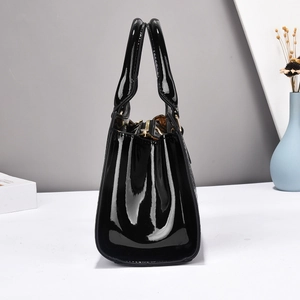 Detail view of the black crocodile pattern handbag with golden zipper and sturdy side shape