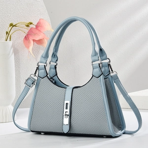 Light blue crossbody saddle bag with woven texture and adjustable strap on white pedestal