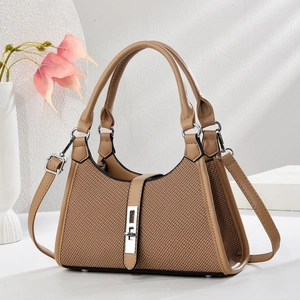 Minimalist brown saddle bag with woven texture, metal lock, and adjustable shoulder strap