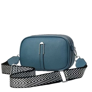 Minimalist misty blue crossbody bag with three zip pockets and zigzag strap