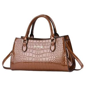 Brown crocodile pattern top handle bag with glossy finish and adjustable shoulder strap