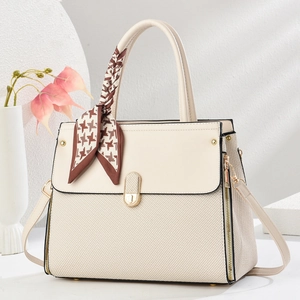 Detail of beige textured handbag with houndstooth silk scarf and gold twist lock