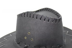 Detalle de sombrero vaquero negro con costuras a mano y ojales metálicos dorados decorativos