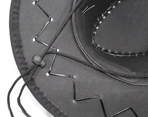 Detalle de sombrero de vaquero negro con textura de malla y costuras en zigzag plateadas