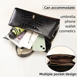 Detail of black faux crocodile handbag interior with multiple zipper compartments and storage