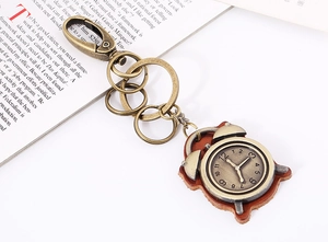 Detail view of retro bronze clock pendant on brown leather keychain with lobster clasp