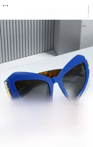 Détail de lunettes de soleil œil-de-chat bleues avec branches écaille et détails dorés