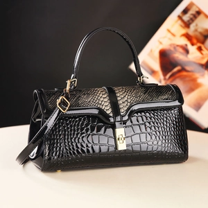 Black patent leather handbag with crocodile pattern and golden snakeskin flap detail