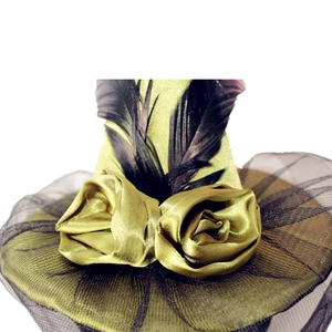 Detail of vintage witch hat headband with green satin roses, mesh, and black feathers