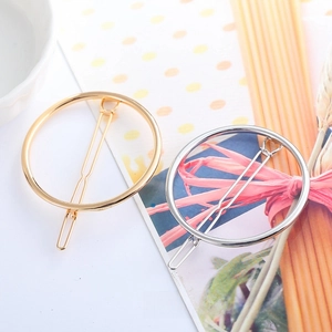 Detailed top view of geometric circular metal hair clips in gold and silver finishes