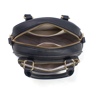 Detailansicht der schwarzen Tasche mit Lychee-Leder, Doppelreißverschluss und Goldbeschlägen