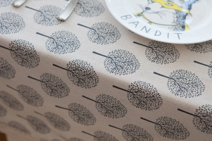 Detailed view of linen texture with black tree patterns on a modern dining tablecloth