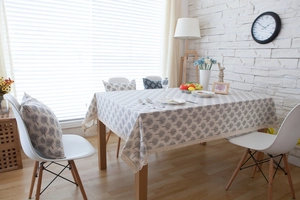 Detail of grey tree pattern linen tablecloth with decorative lace edges and matching pillow